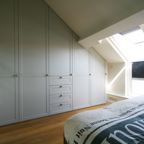 Bij de renovatie van hun woning wouden de bewoners in de slaapkamer een handige kleerkast. Wij zorgden ervoor dat de ruimte onder het schuin dak volledig gebruikt kon worden.  We zorgden er eveneens voor dat de kleerkast geen 'zware' indruk geeft. Verder werden de hoeken ook in hetzelfde materiaal van de draaideuren uitgewerkt zodat het als één geheel overkomt. Kast-ID Antwerpen