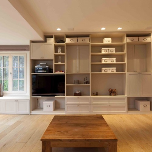 Les propriétaires voulaient une armoire sur mesure dans le living. Celle-ci a été pourvue de portes pivotantes et de parties ouvertes dans lesquelles peuvent être exposés de nombreux souvenirs,