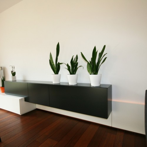 Dans ce salon, nous avons recherché un mélange entre un concept ludique et un espace de rangement suffisant. L’éclairage LED intégré assure une ambiance douillette.  Kast-ID Anvers