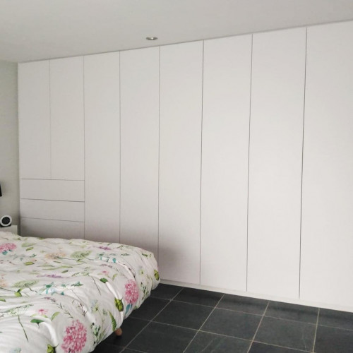 Voor deze klant realiseerden we een kamershoge kastenwand in de slaapkamer. Een leuke extra: ook de zwevende nachtkastjes werden op maat door ons voorzien!