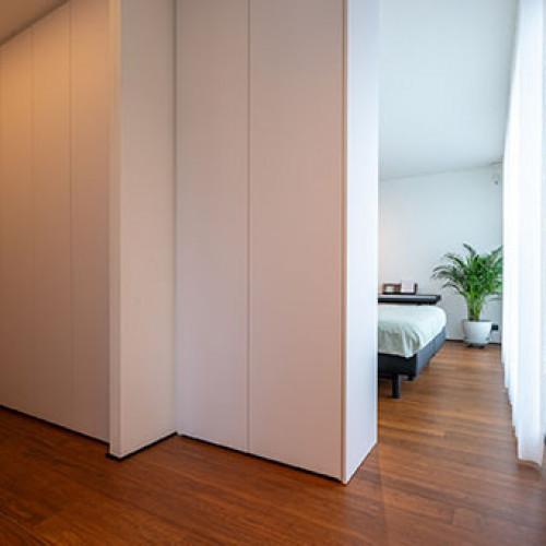 Voor deze klant realiseerden we een ruime inloopdressing in de slaapkamer. Door middel van kamershoge maatkasten werden dressing en slaapgedeelte van elkaar gescheiden. Om het geheel strak te houden, koos de klant voor witte kasten zonder greep, voorzien van tip-on systeem. 